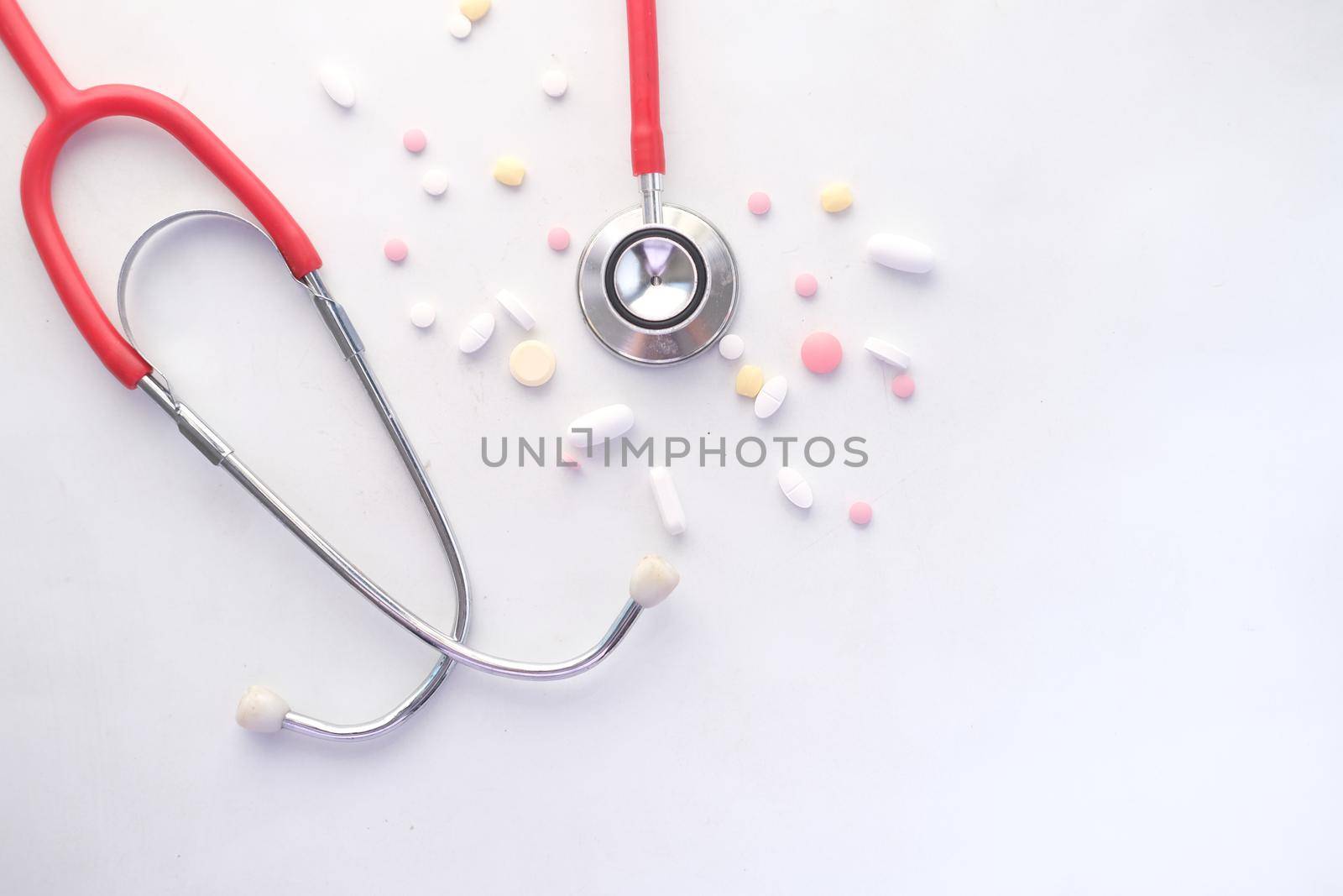 medical pills and stethoscope on white background .