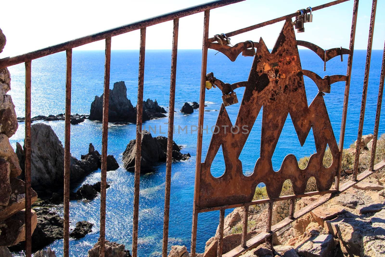 Romantic padlocks hanging on The Reef of the Sirens railing in Cabo de Gata-Nijar, Almeria, Spain