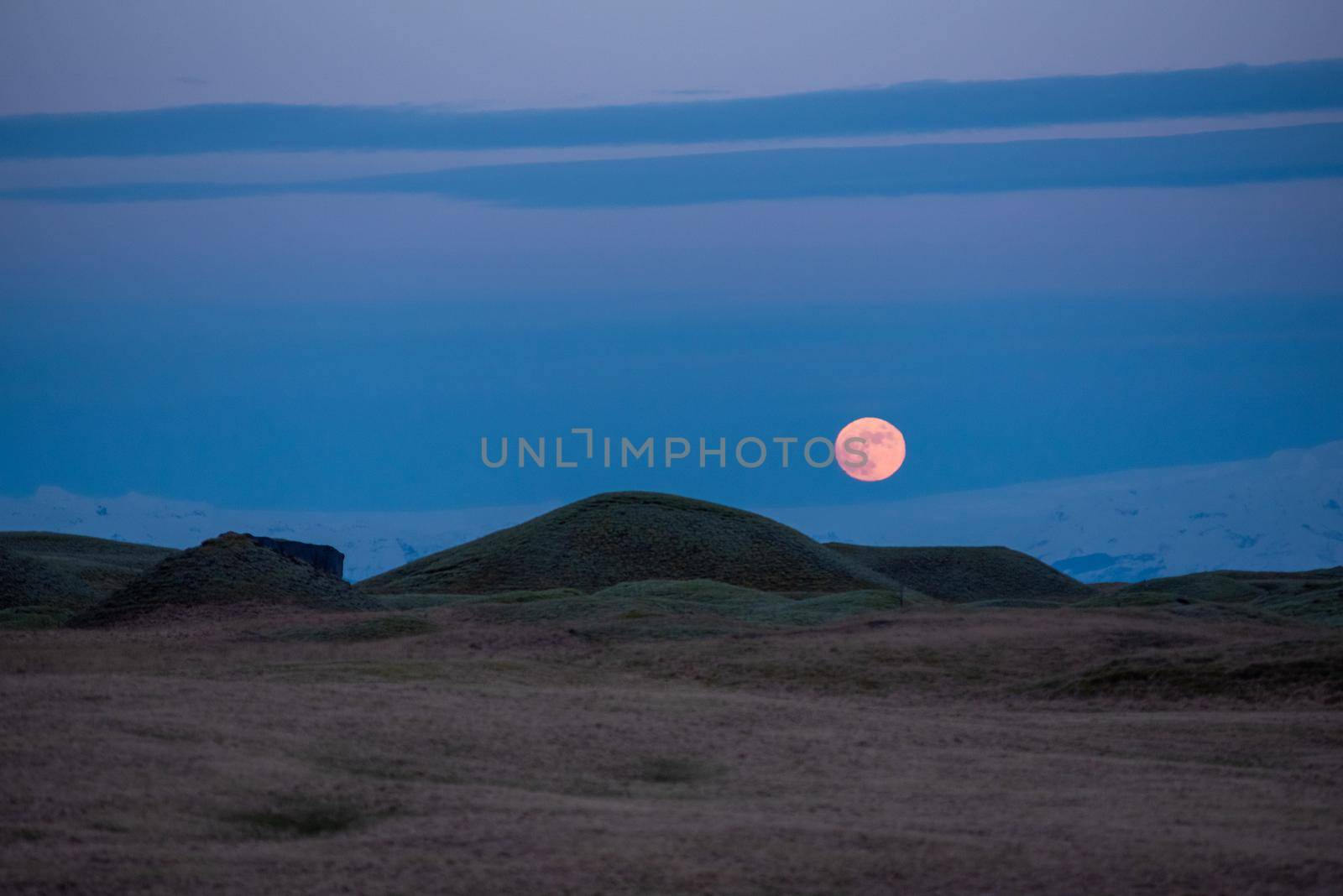Full moon rise over Iceland glacier with rolling hills in the foreground by jyurinko