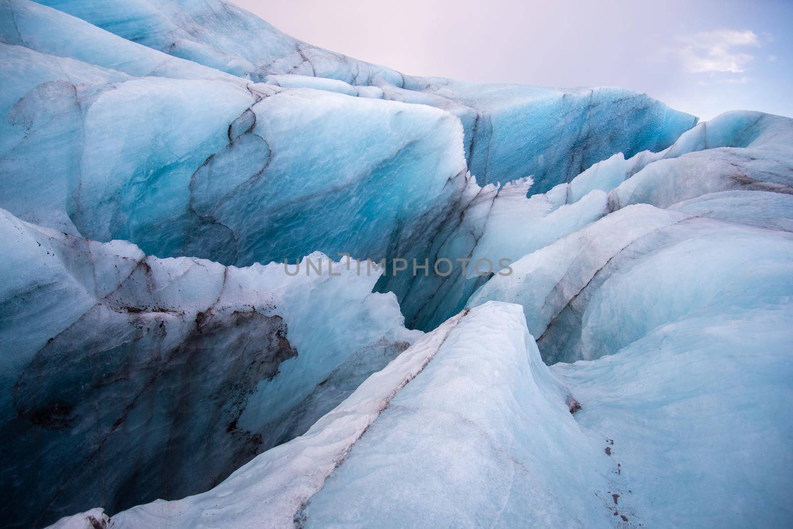 Detail Icelandic glacier image bright blue glacier abstract closeup texture image with black lines from volcanic ash