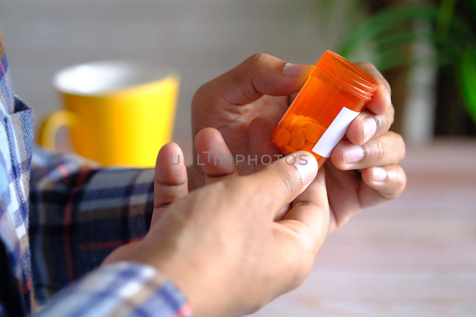 rear view of young man hand hold a medical pill container .