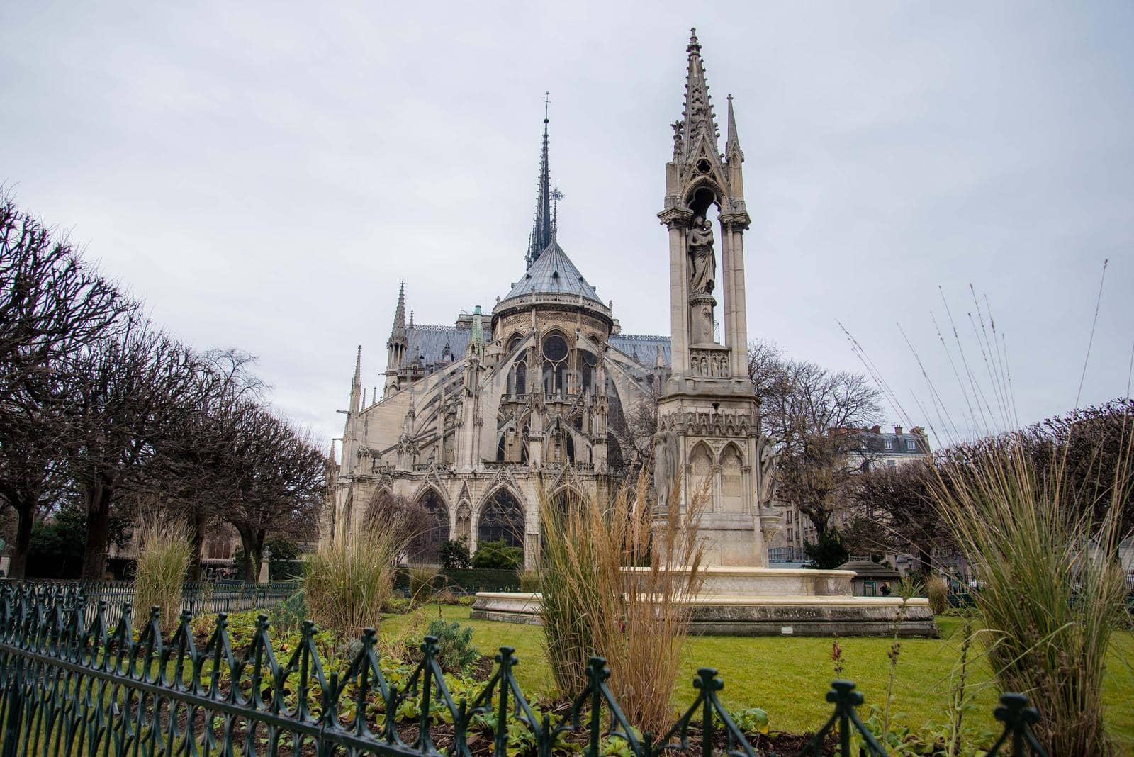Paris, France - February 3, 2017: Peering over gothic fence at the world famous Notre Dame de Paris. Frontal view