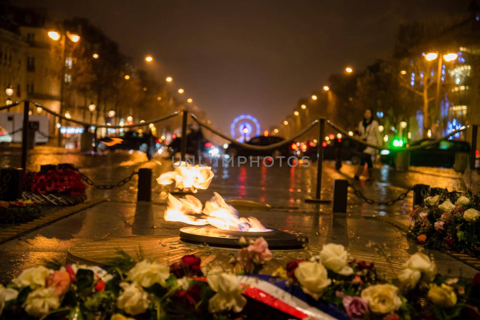 Paris, France - February 3, 2017: World famous Arc de Triomphe flowers and flame at the city center of Paris, France. Detail view from arc looking out to wheel