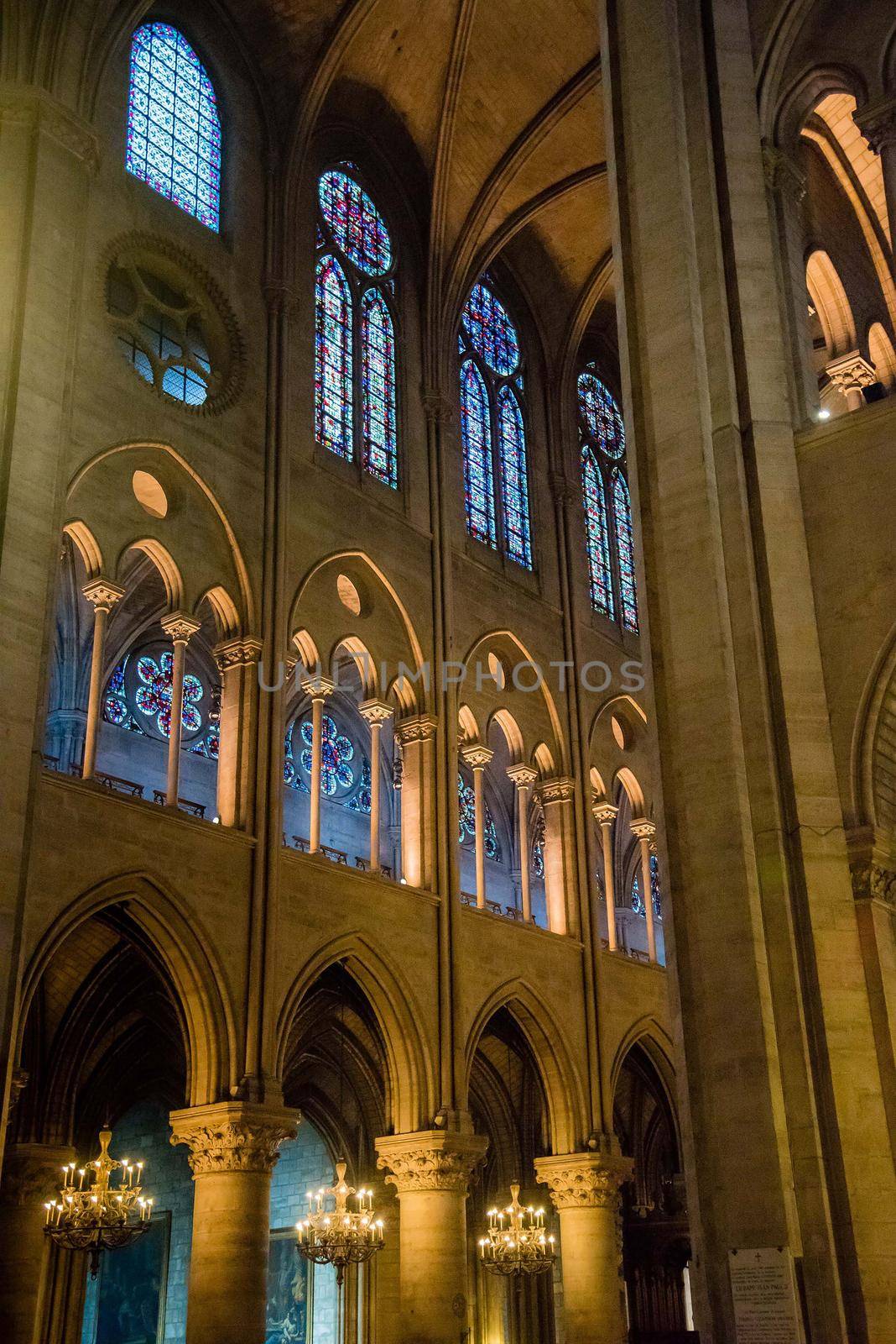 Paris, France Inside Cathedrale Notre-Dame de Paris. Vertical crop of stained glass windows.
