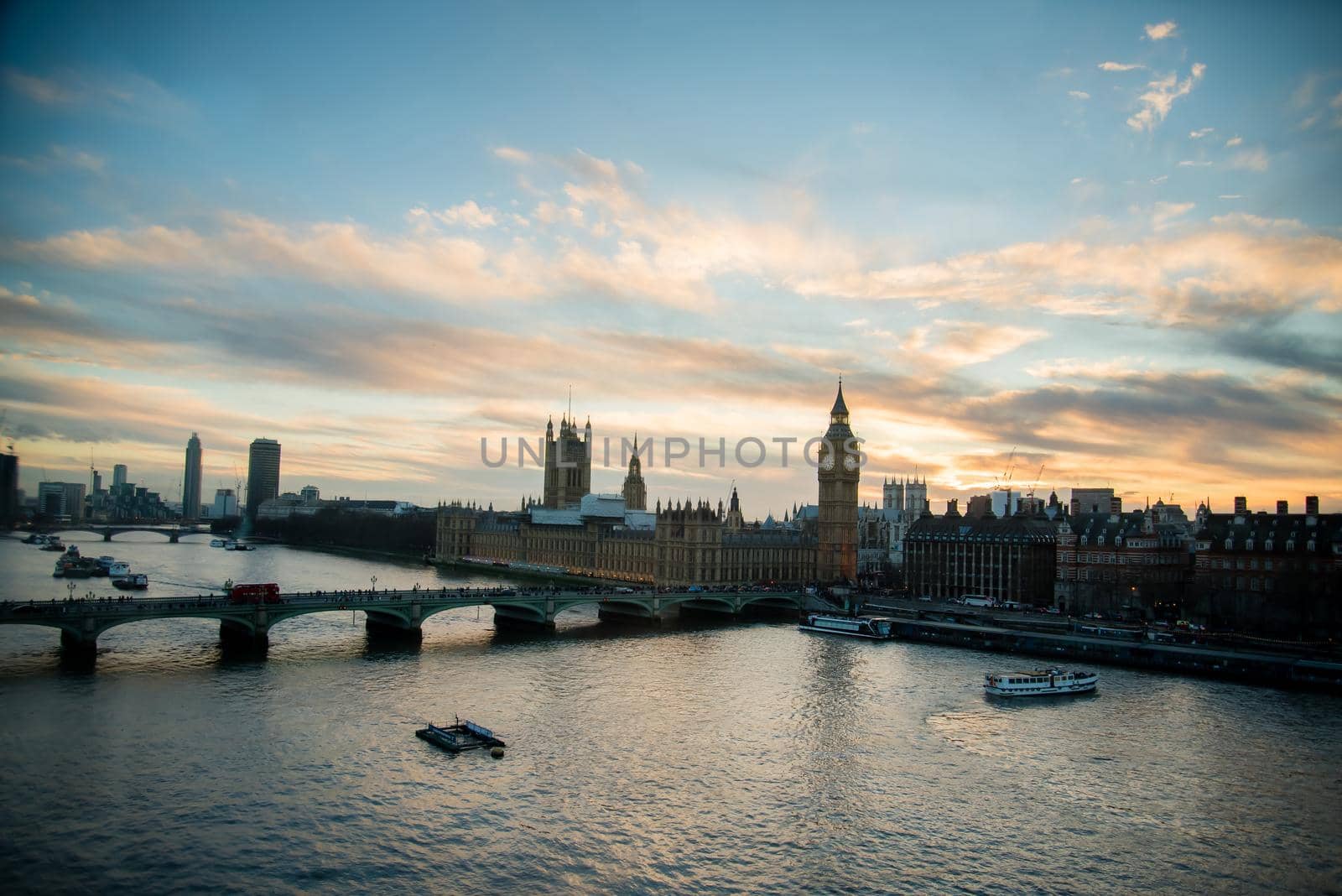 London skyline view at sunset with famous landmarks, Big Ben, Houses of Parliament and ships on River Thames with beautiful blue and yellow sky. by jyurinko