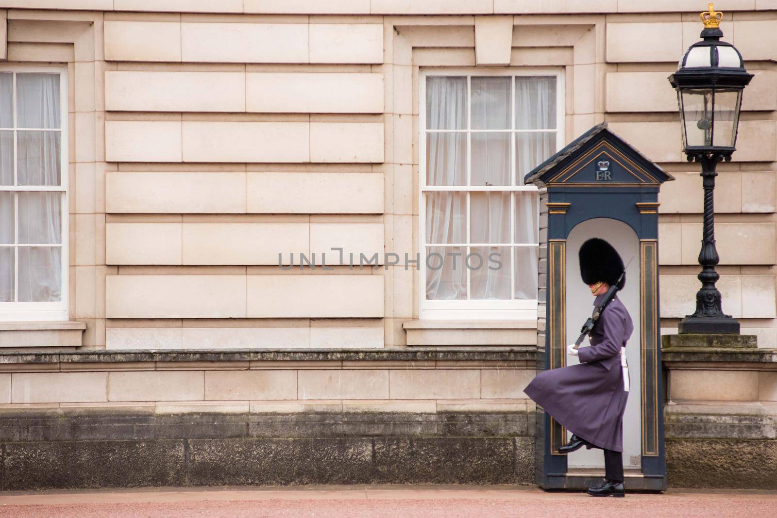 London, UK - January 29, 2017: An action photo from changing of the guards at Buckingham Palace in London with guard marching from phone booth area.