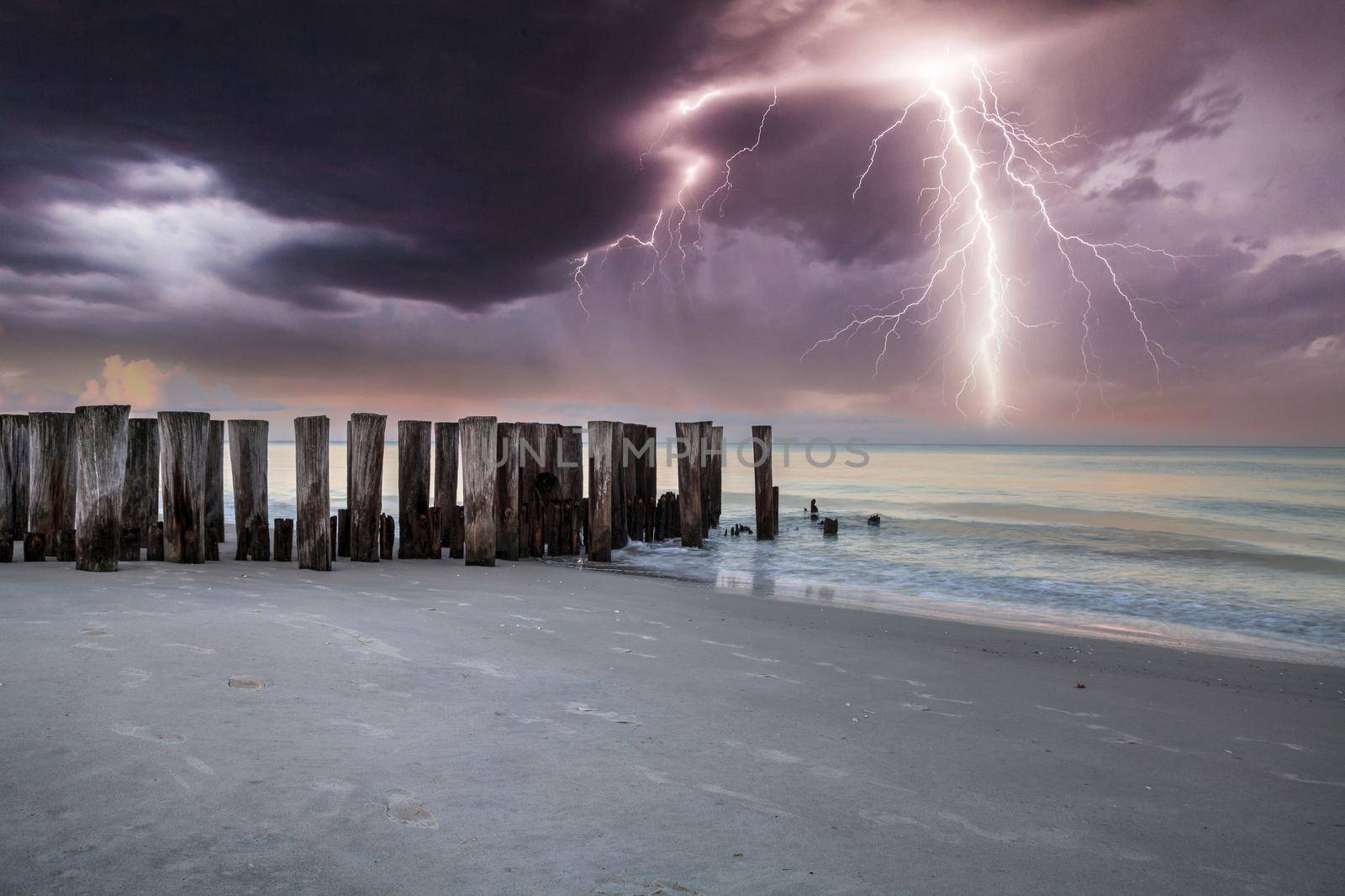 Lightning storm over the ocean at Port Royal Beach in Naples, Florida at sunrise.
