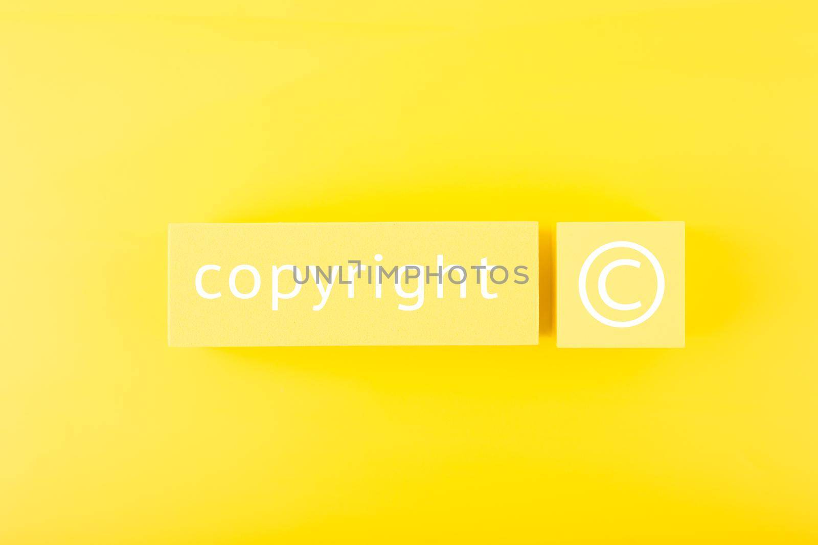 Minimal trendy copyright and patenting concept. Copyright word and symbol on yellow blocks against yellow background