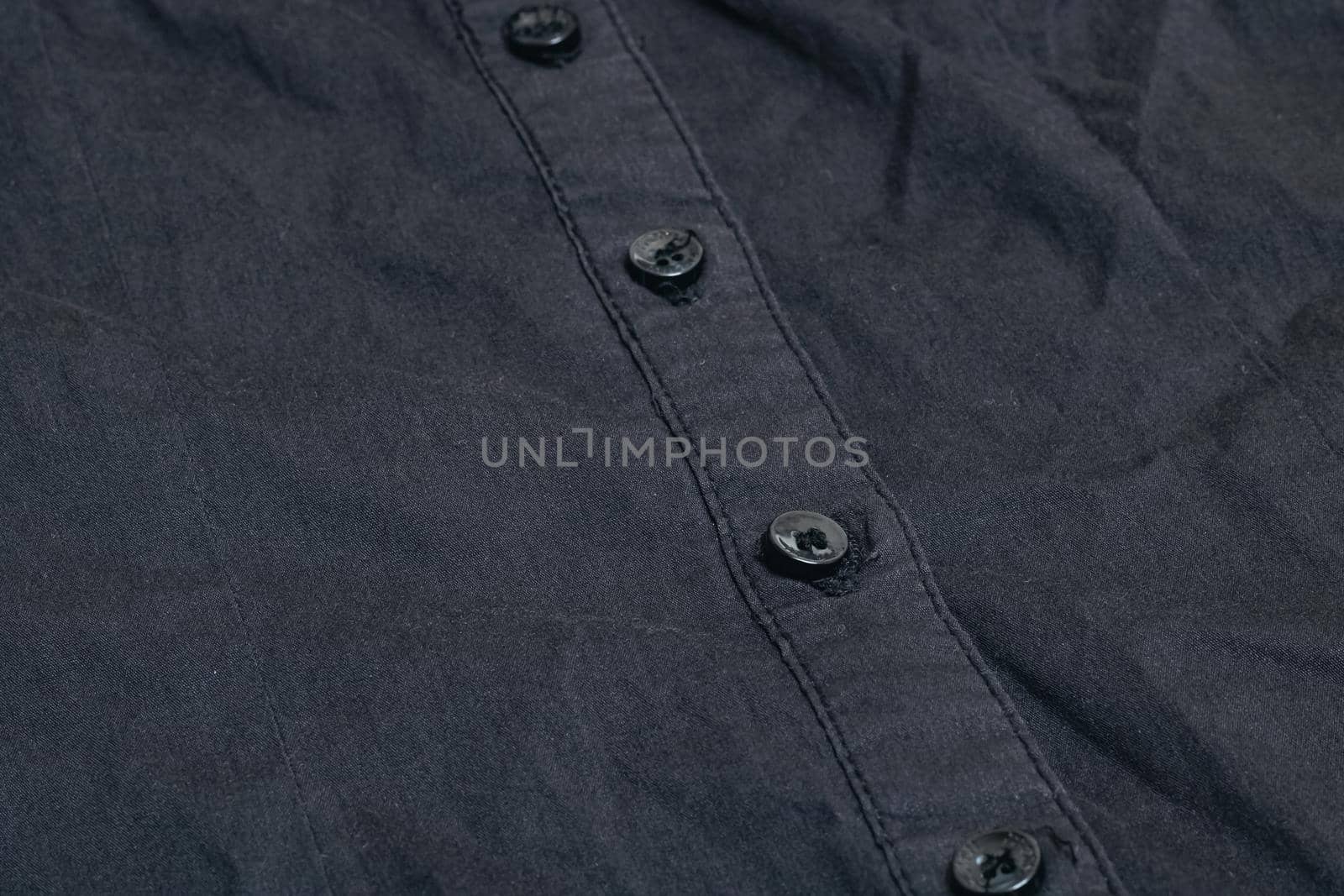 Buttons on a black shirt close up, macro photo
