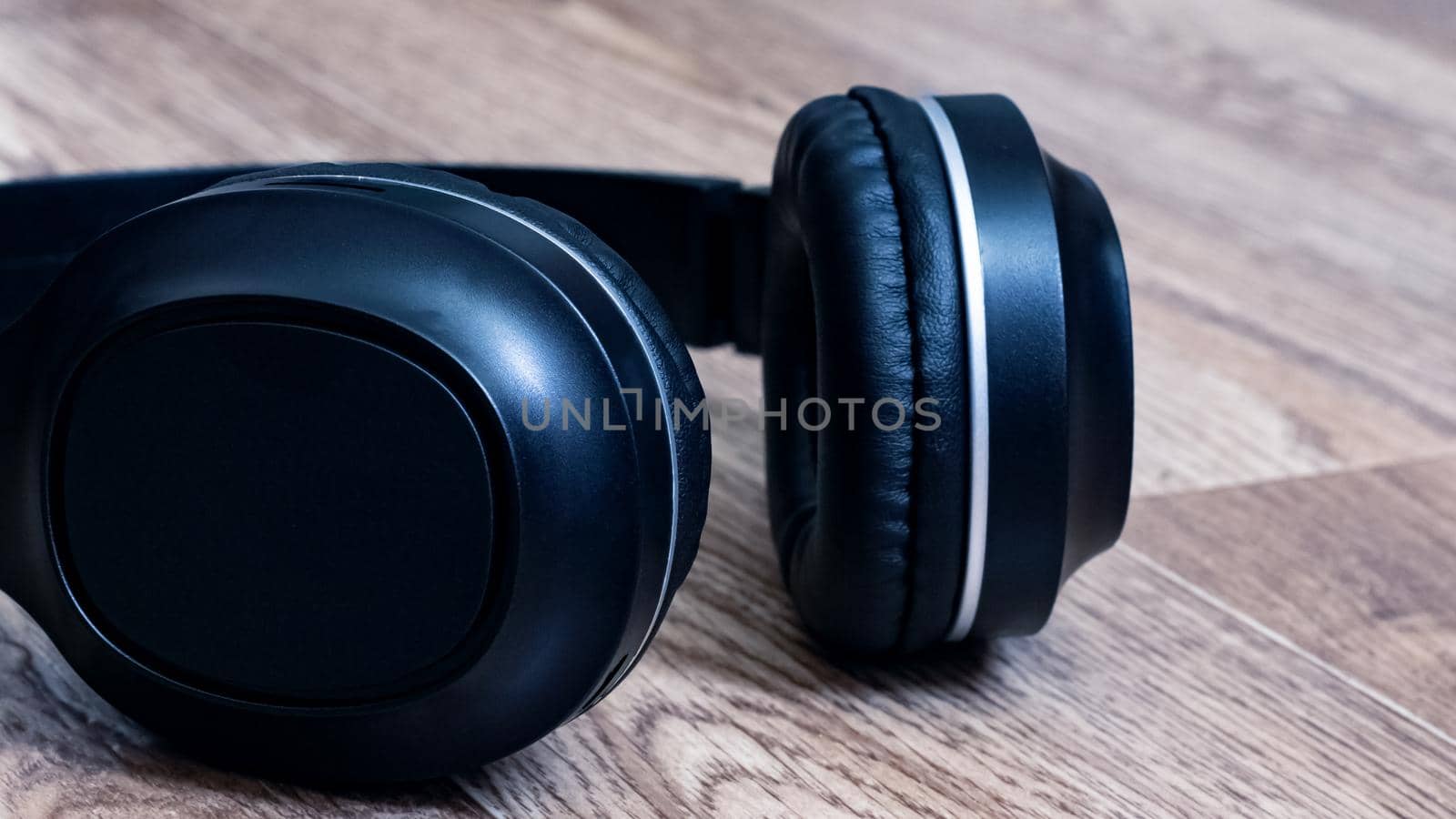 Black headphones on a wooden background close up