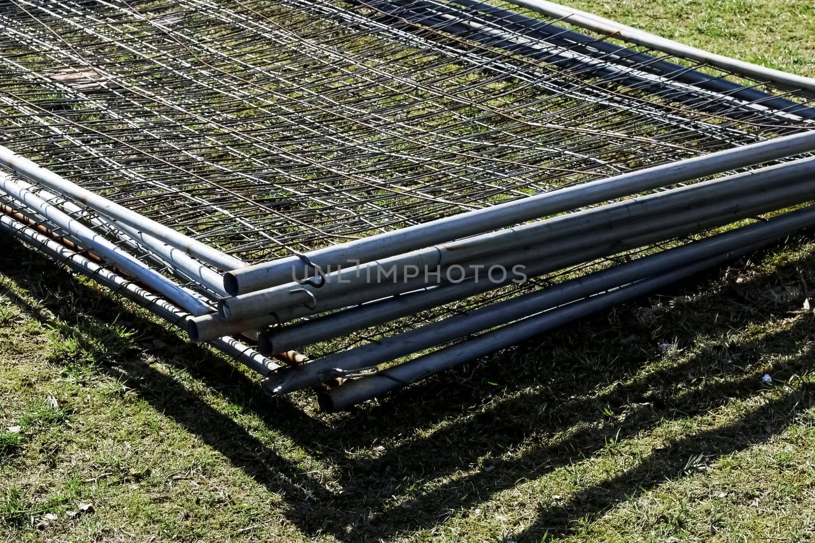 Metal fence mesh folded on the grass close up