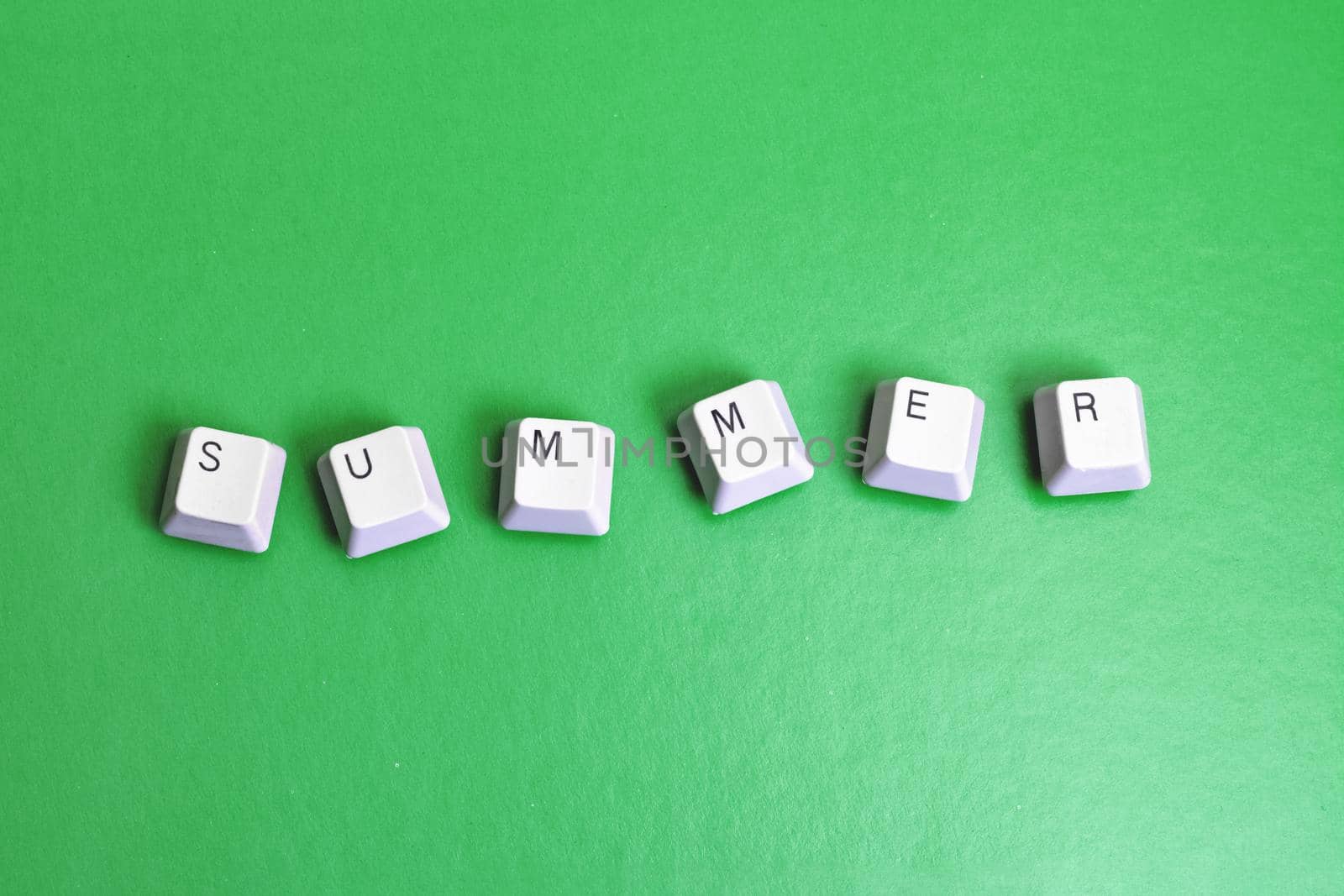 Word summer made of cubes on a green background close up