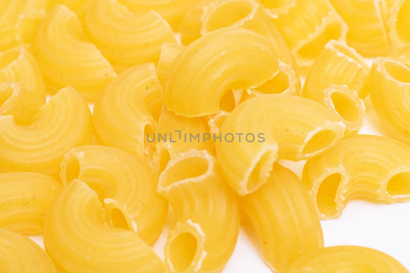 Yellow pasta horns close up, abstract background or texture