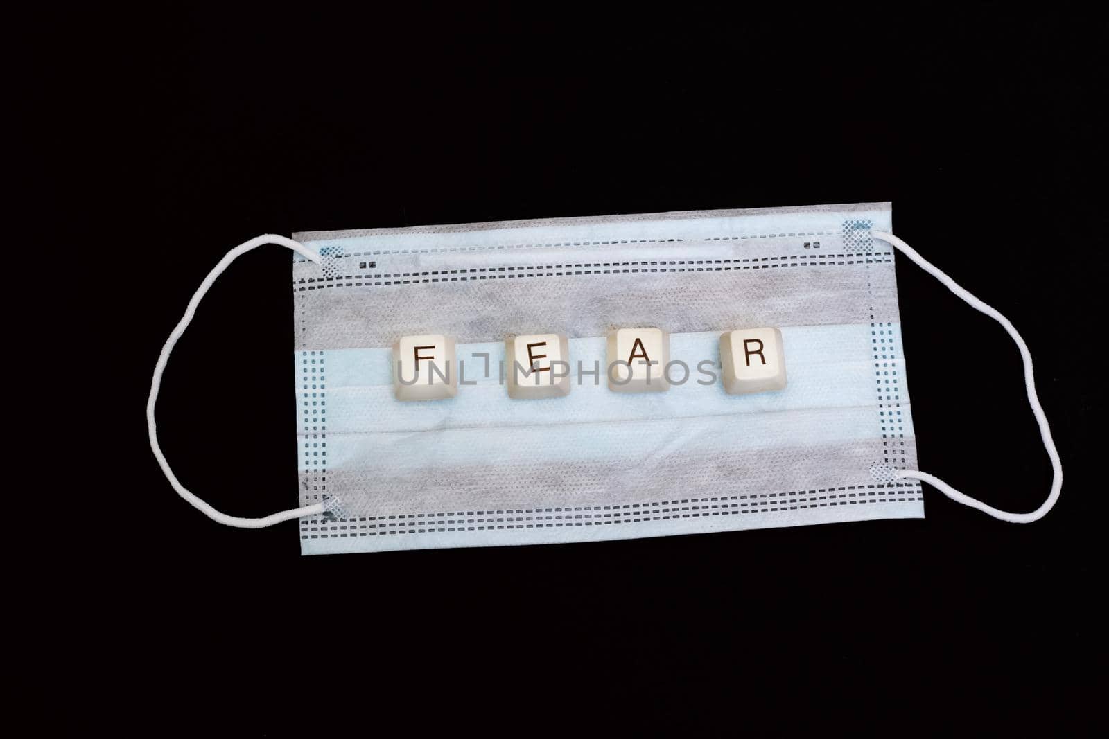 The word fear made of keys on a medical mask