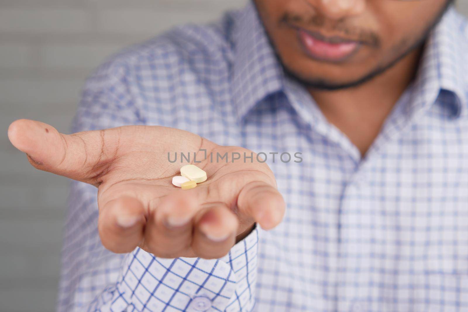 upset man hand holding medical pills .