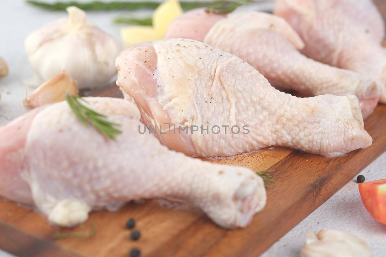 raw chicken drumstick on a chopping board by towfiq007