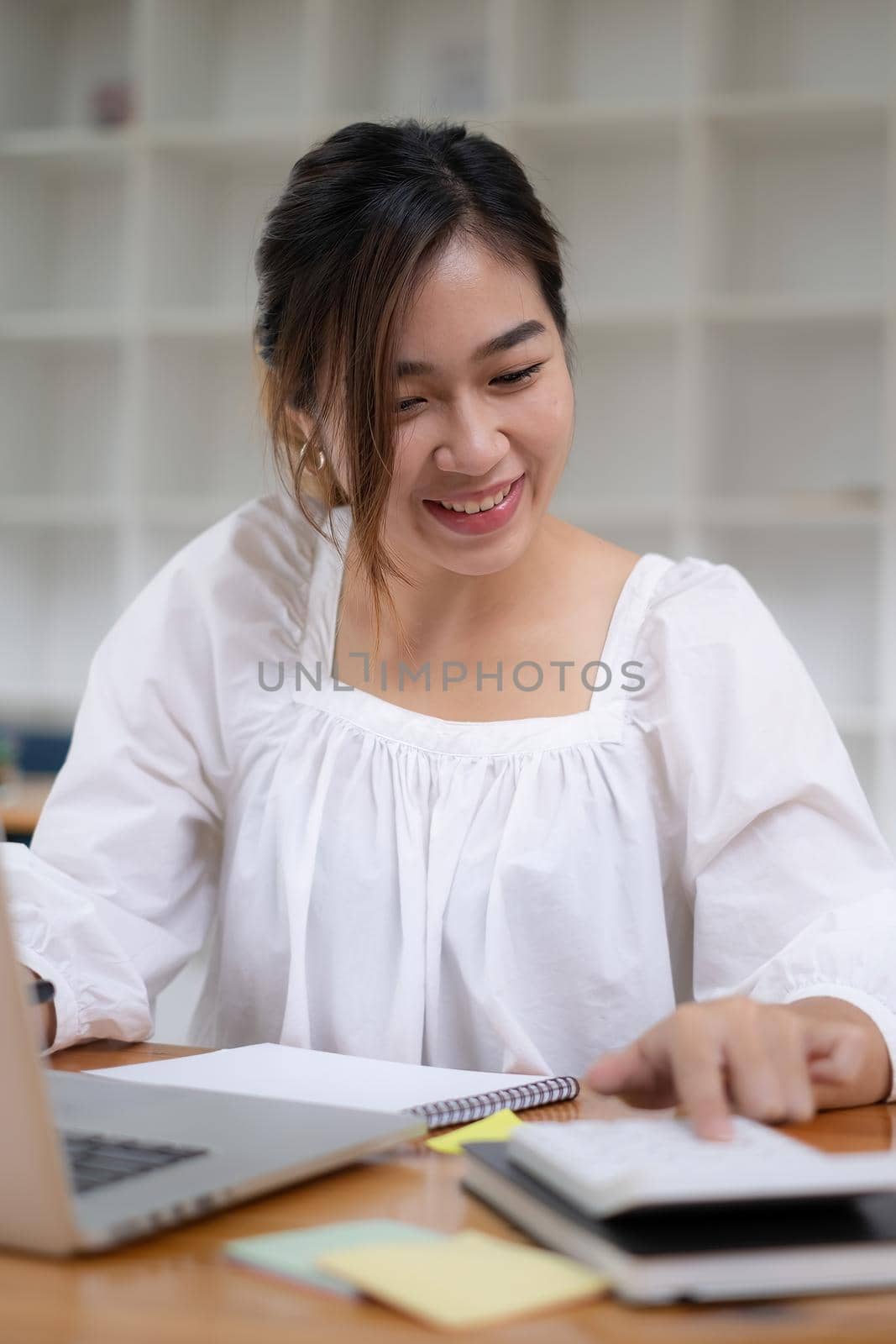 Photo of gorgeous secretary working at office. she sitting at the wooden desk.