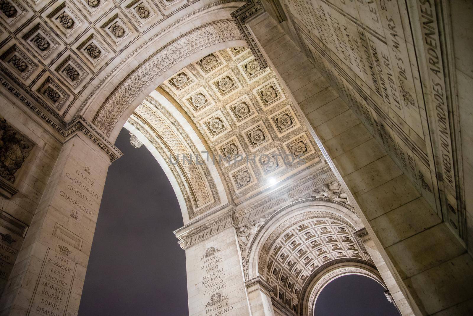 World famous Arc de Triomphe at the city center of Paris, France. Under arch view by jyurinko