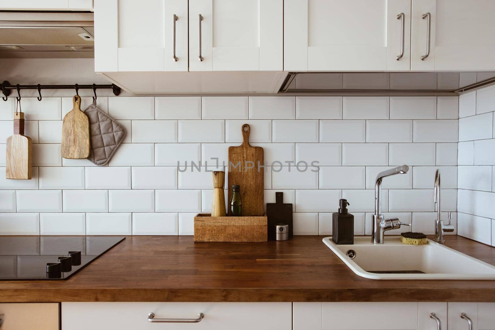 Kitchen brass utensils, chef accessories. Hanging kitchen with white tiles wall and wood tabletop.Kitchen background by katrinaera