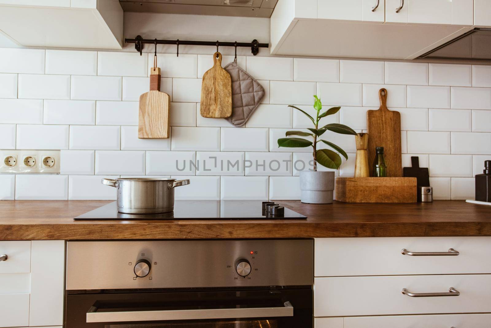 Boiling water in a cooking pot an a pan on a induction stove in the modern white kitchen by katrinaera