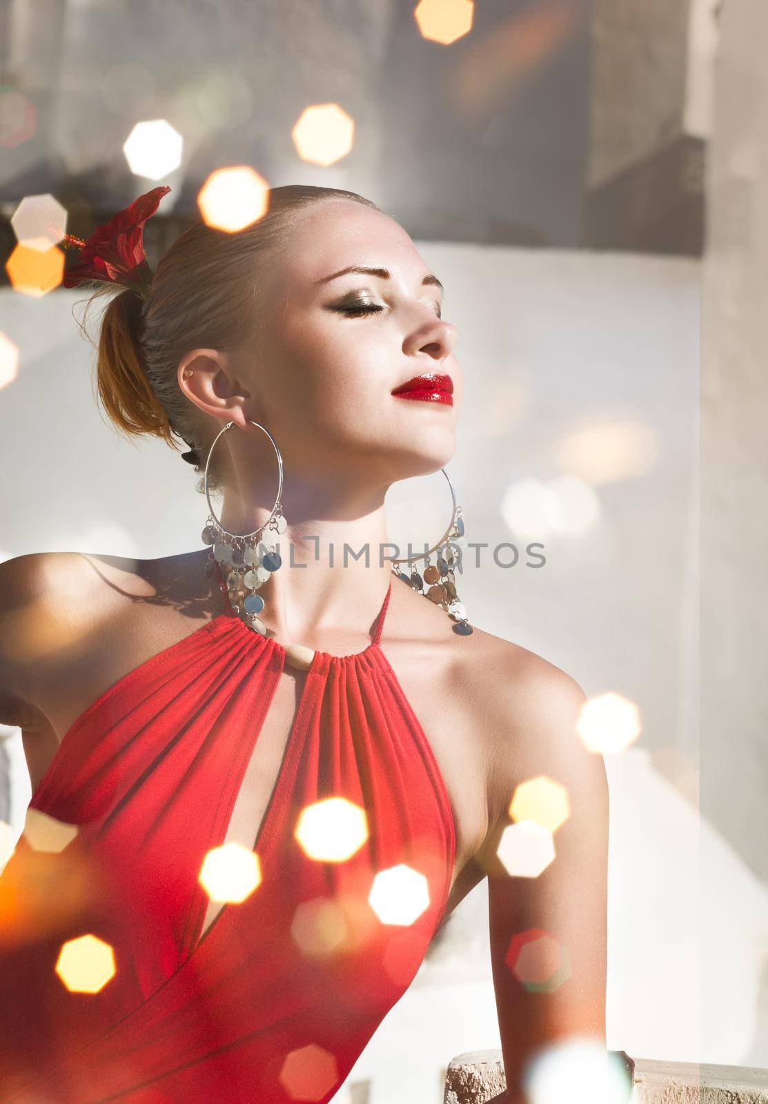 Attractive flamenco dancer wearing traditional red dress with flower in her hair