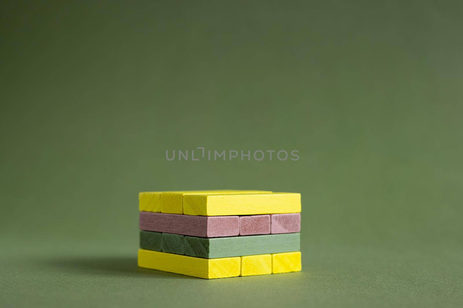 Jenga wood colourful green and yellow on green background copy space, platform for product. by katrinaera