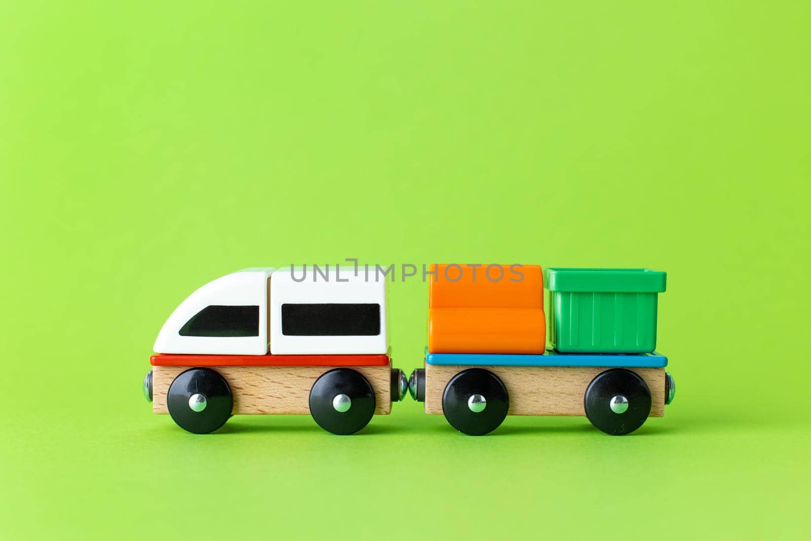 Train children toy, preschool kids game. Locomotive and carriages, wooden colorful blocks construction on green color background by katrinaera