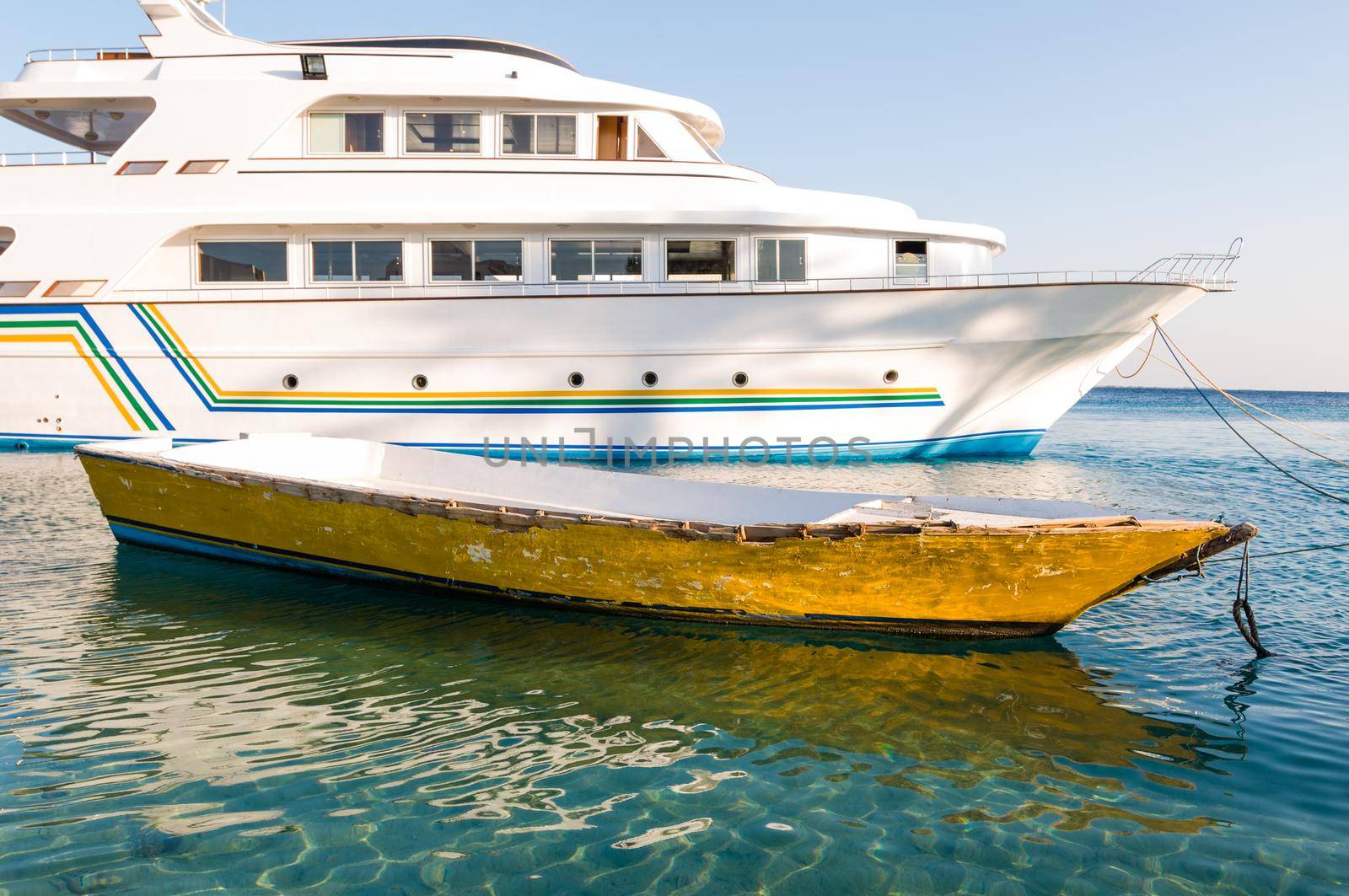 Old boat and modern yacht together in harbour