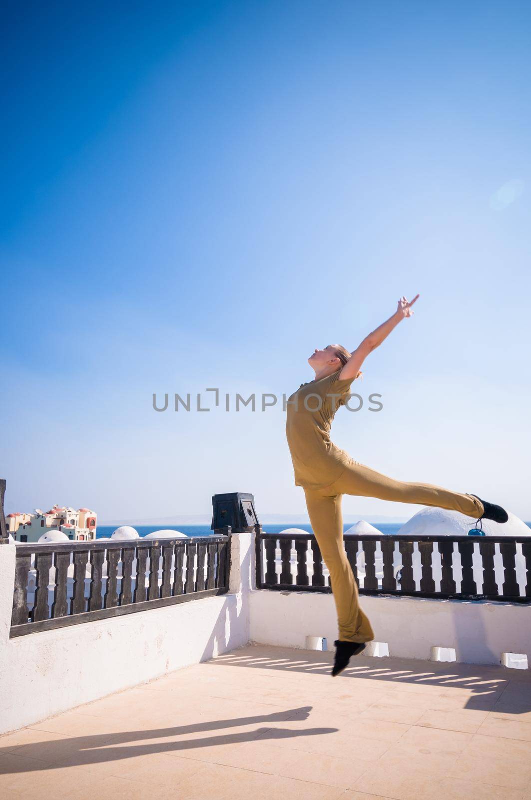 Attractive redhair woman practicing Vinyasa yoga outdoors