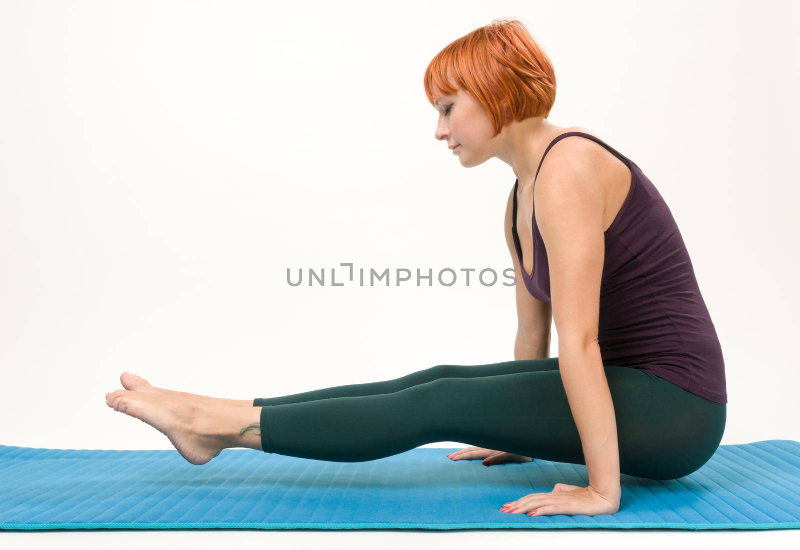 Young beautiful yoga posing on a gray studio background