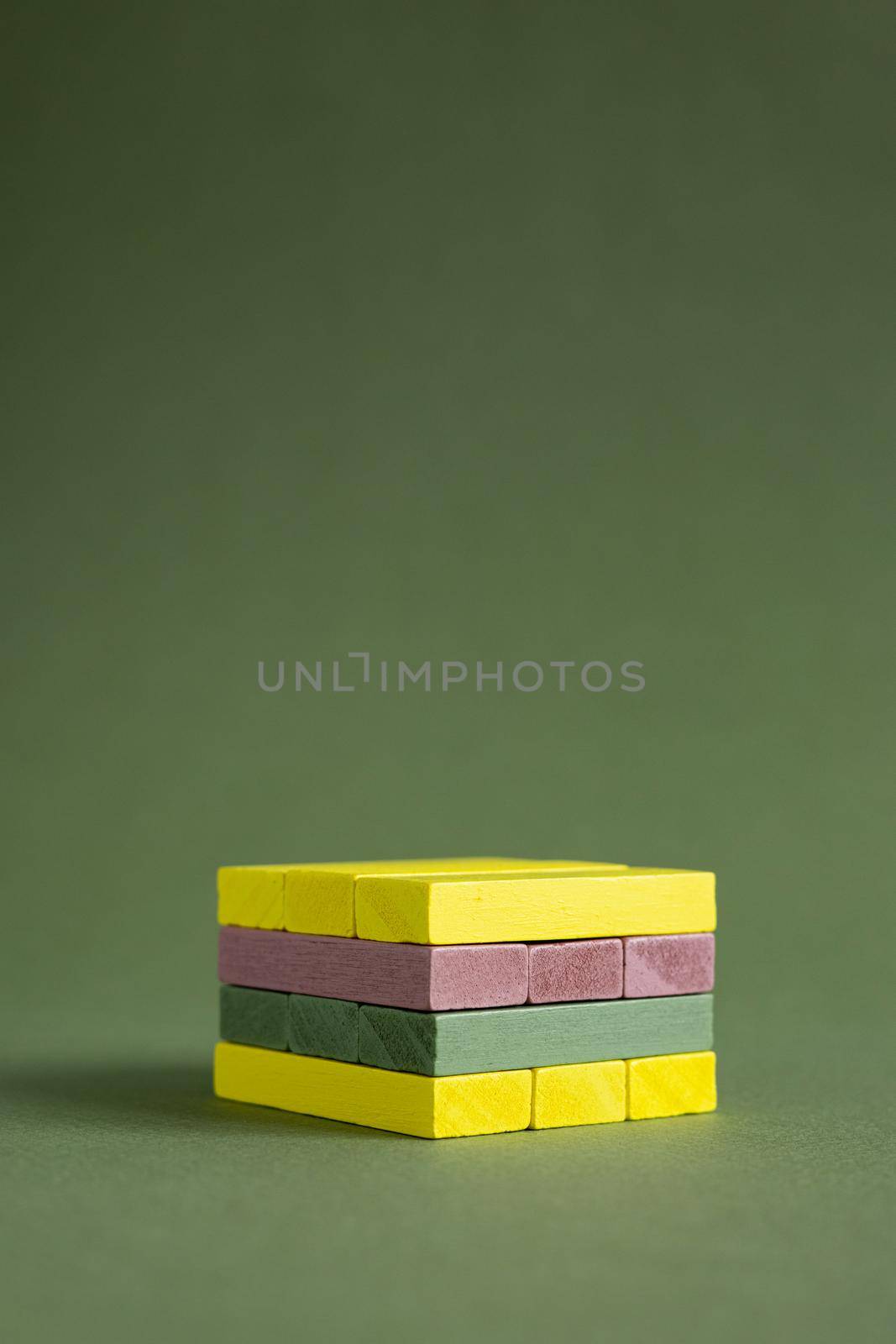 Jenga wood colourful green and yellow on green background copy space, platform for product copy space 