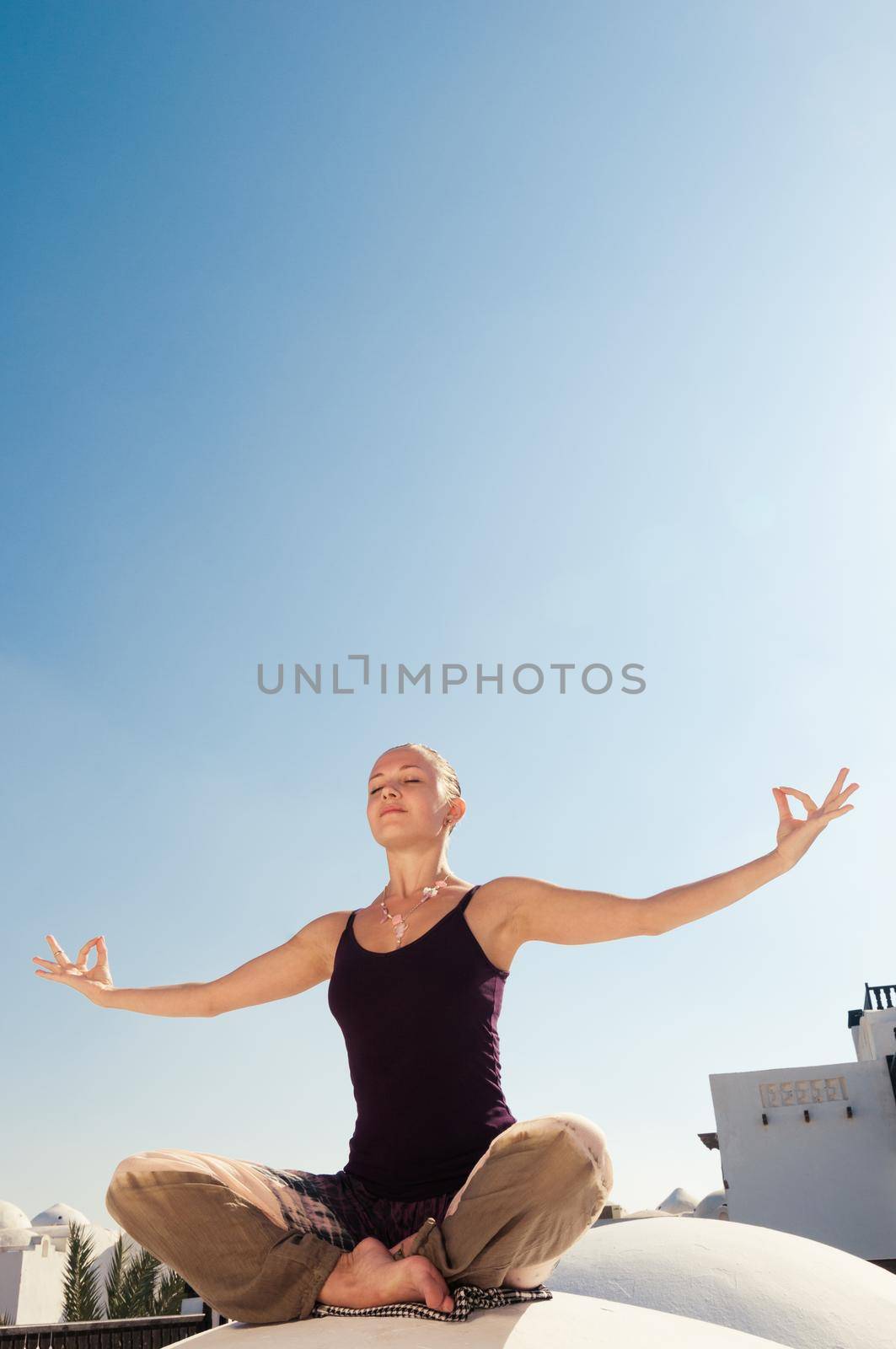 Attractive redhair woman practicing Vinyasa yoga outdoors