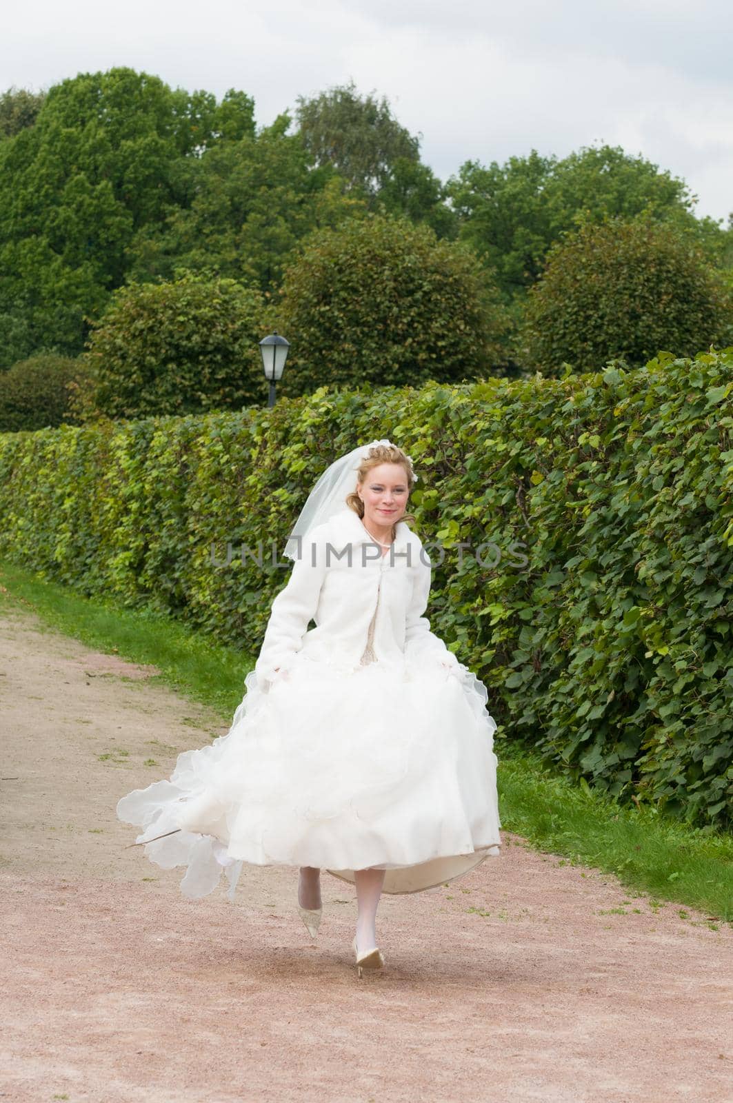Happy Young bride running in beautiful park