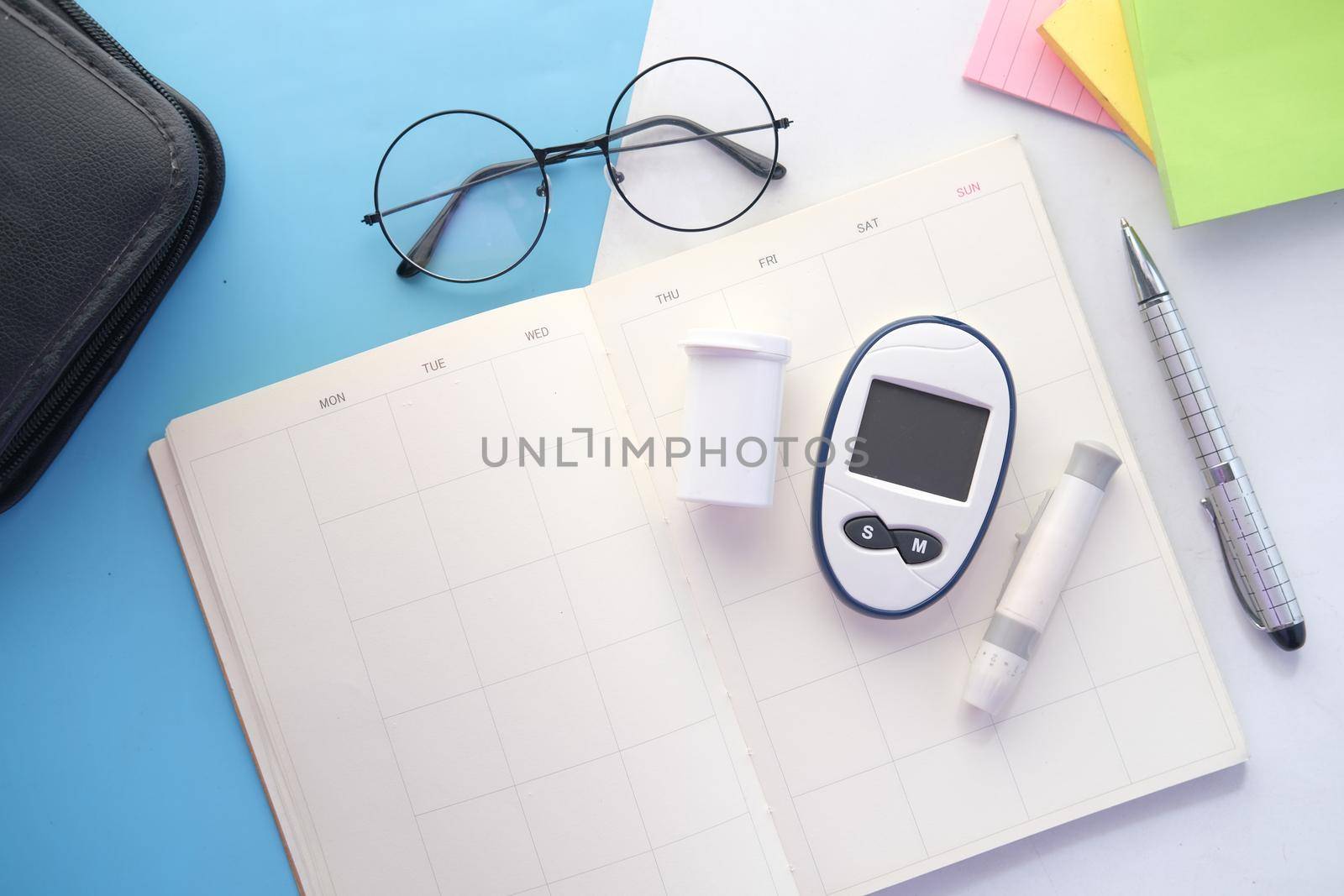 diabetic measurement tools on a planner on table .