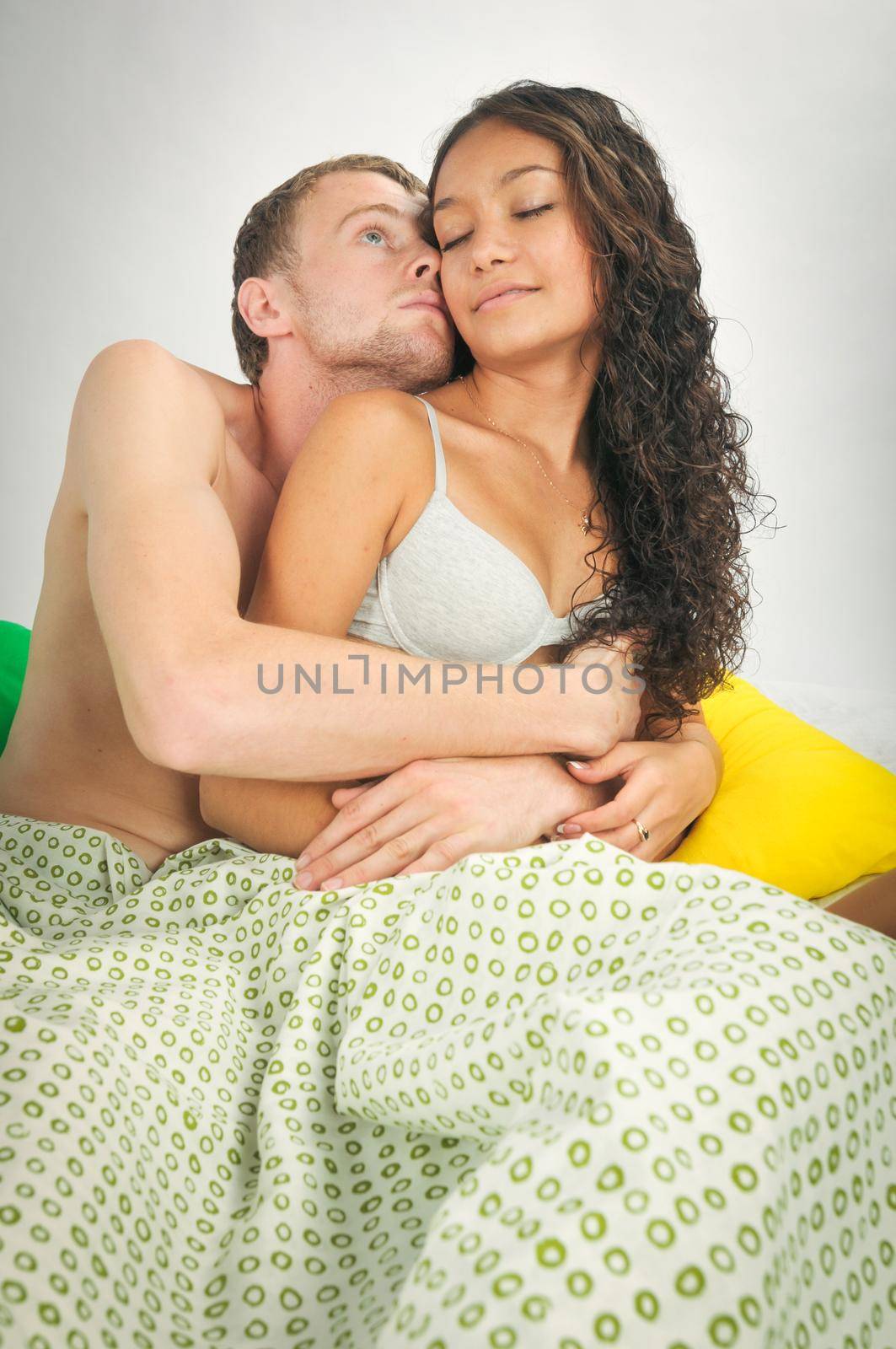 Young caucasian heterosexual couple in bed at home