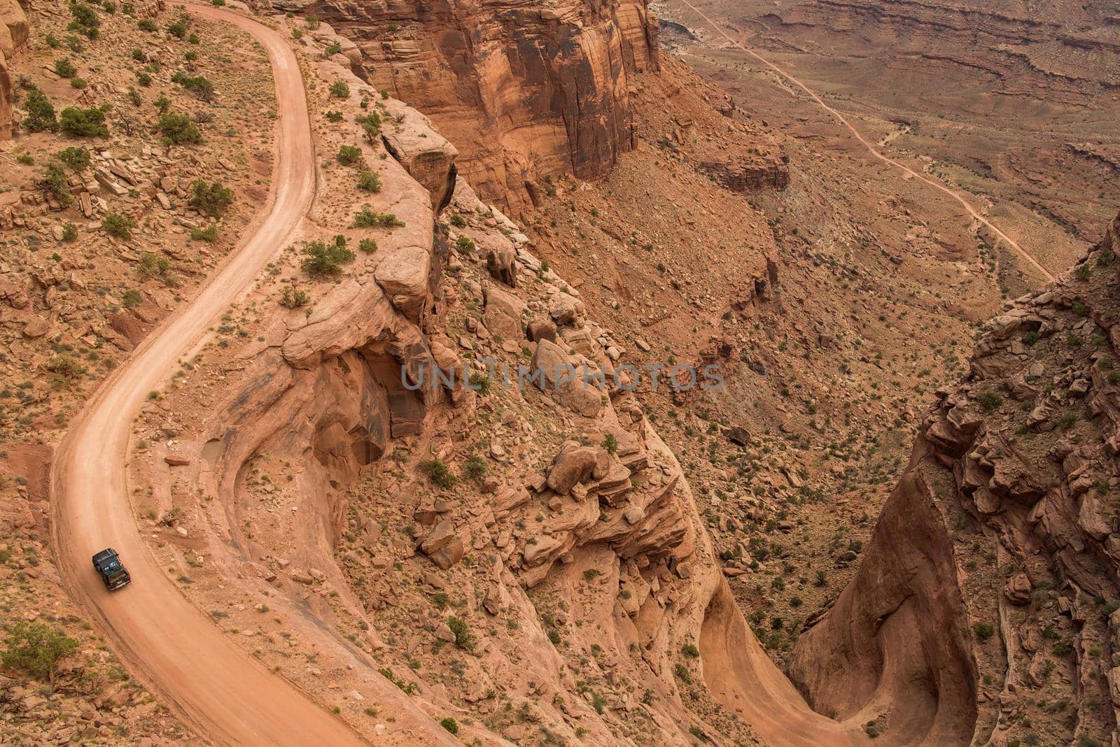 Jeep on dirt road winding through Canyonland Nationals Park in Utah. by jyurinko