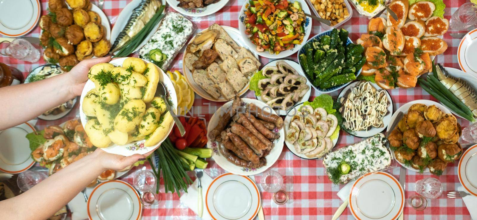 A lot of different food on the Banquet table and served boiled potatoes with dill.A large number of ready-made dishes on the table.Holiday at the table.
