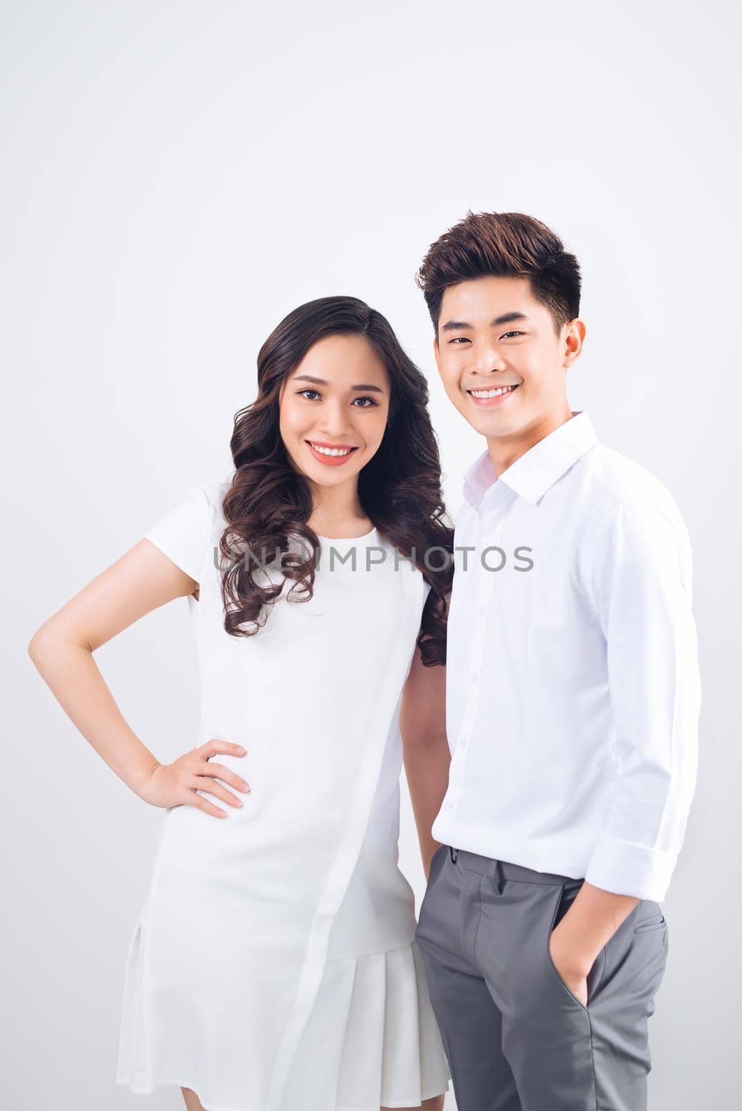 Happy together. Young in love couple smiling and standing against background