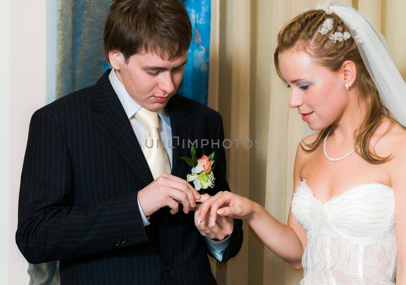 Young wedding couple putting the ring by nikitabuida