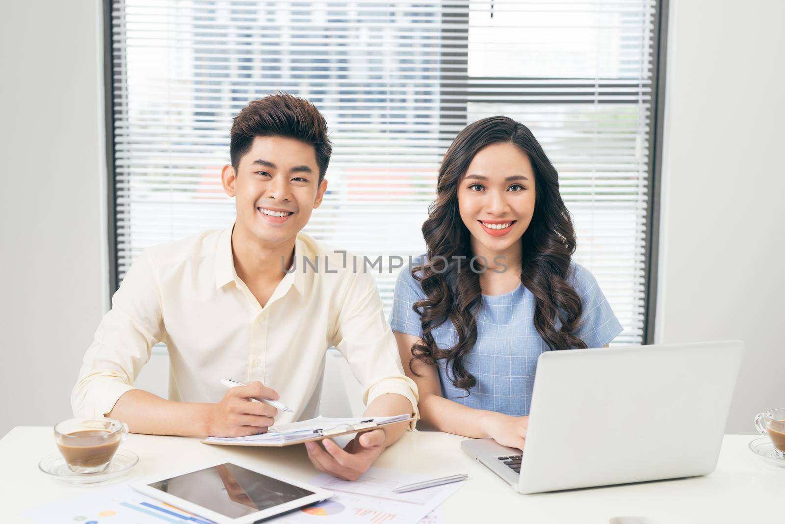 Business people working with computer and doing some paperwork while sitting at desk 