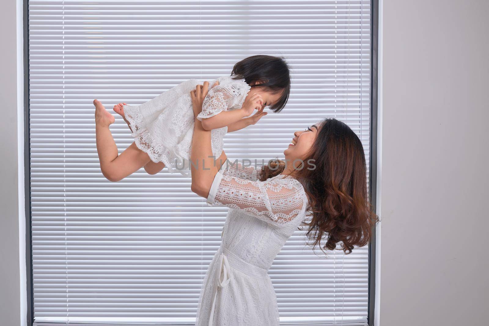 Mother and baby girl making fun in living room.Laughing.Mother holding her daughter.