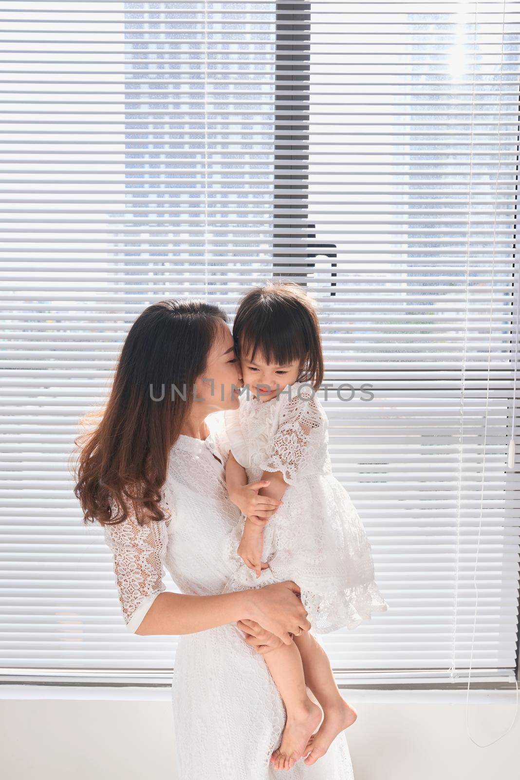 Mother and baby girl making fun in living room.Laughing.Mother holding her daughter. by makidotvn