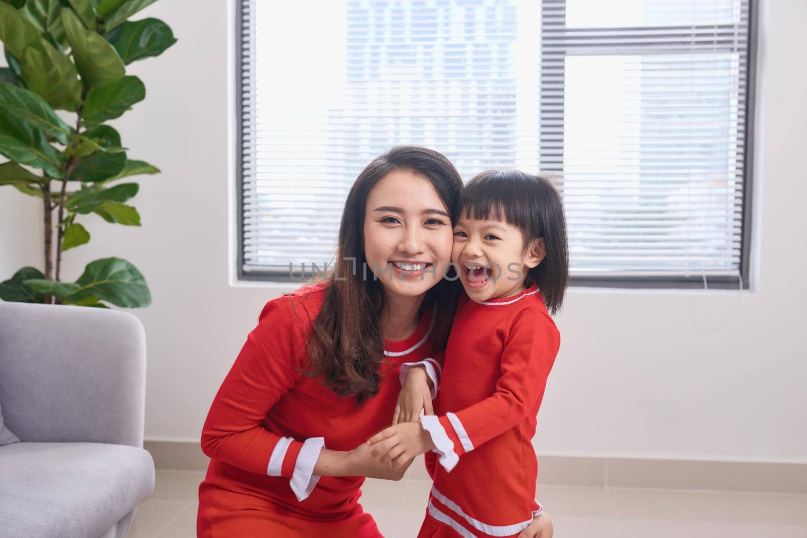 Happy young mother laughing with her little daughter in the morning. Having fun together. Joyful family time at home.  by makidotvn