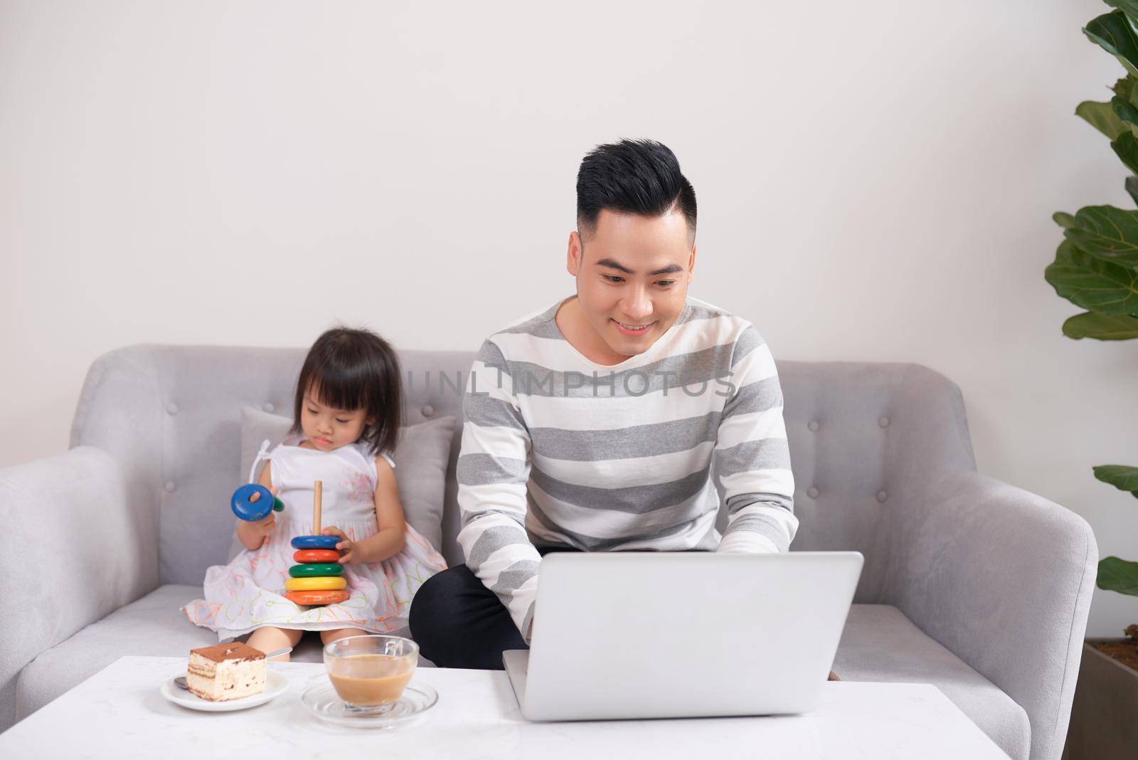 Father and his teenage daughter playing on a portable computer at home. by makidotvn