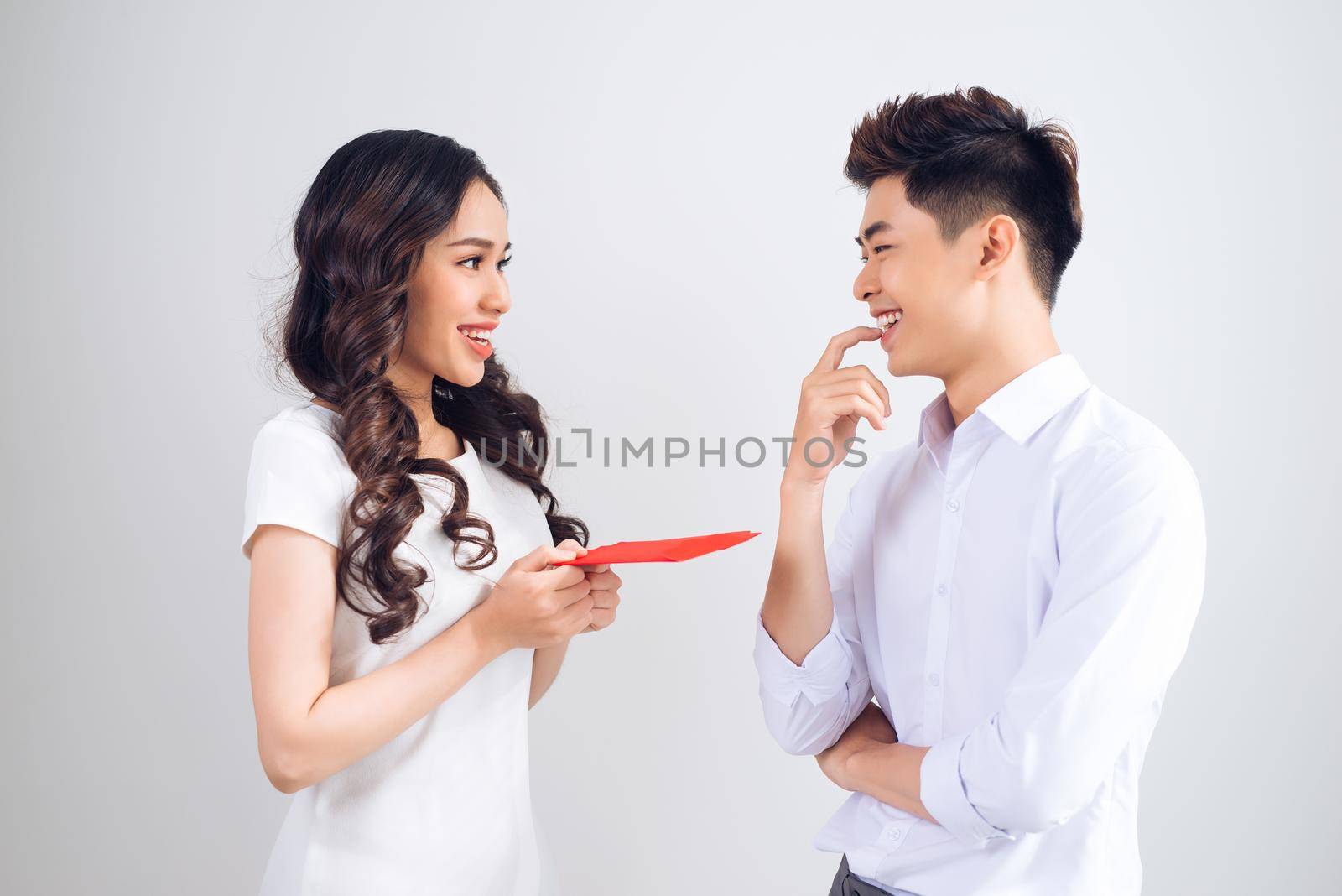 Vietnamese couple exchanging red lucky money envelopes. Tet holiday.