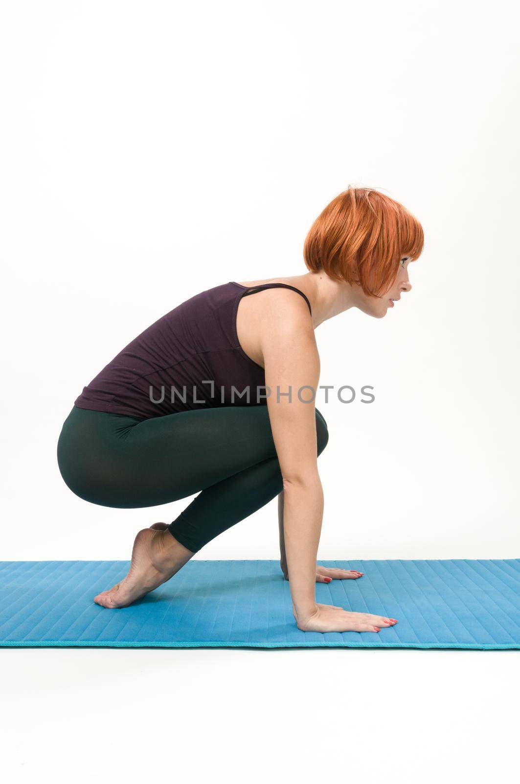 Yoga posing on a gray studio background by nikitabuida