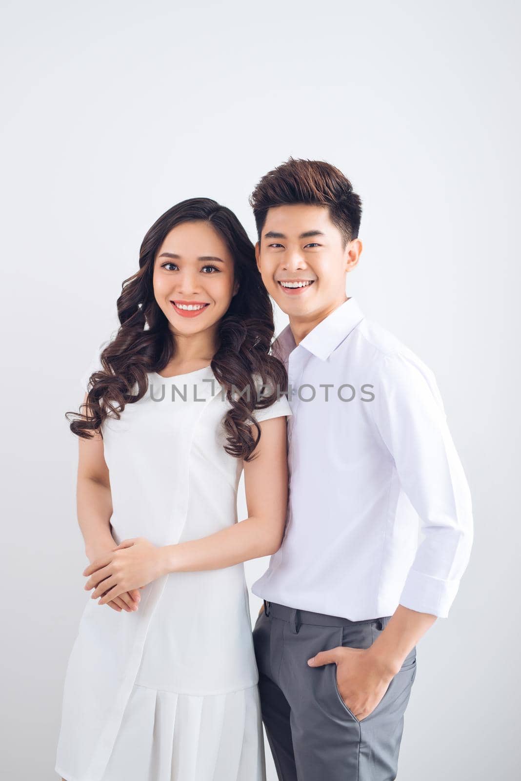 Happy together. Young in love couple smiling and standing against background