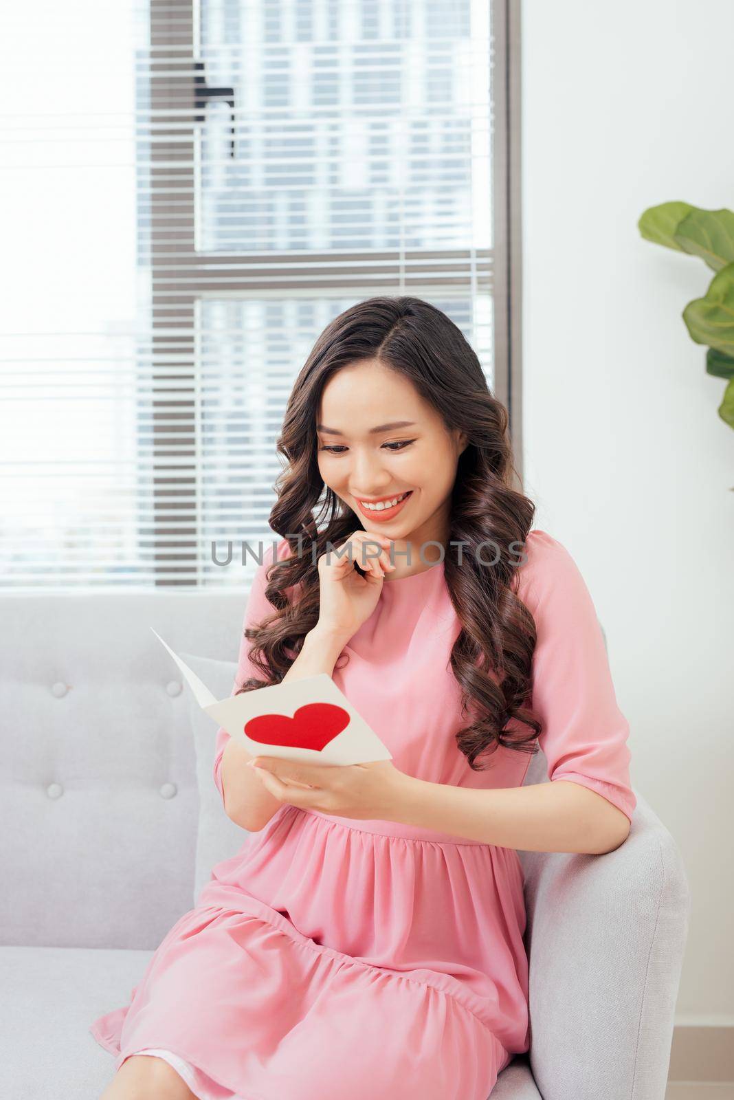 Cute girl reading a love card from her boyfriend