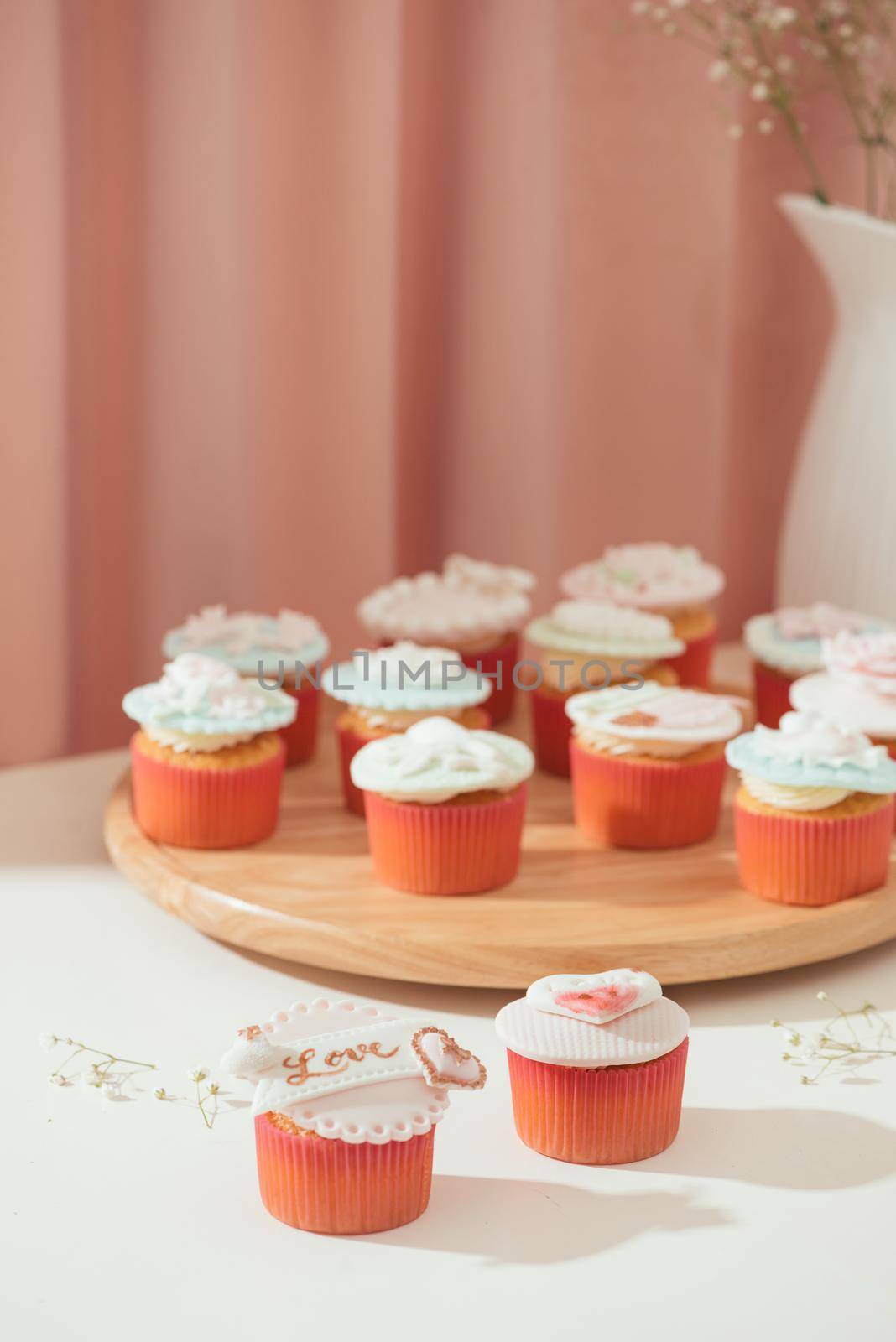 Many yummy cupcakes. Valentine sweet love cupcake on table on light background by makidotvn