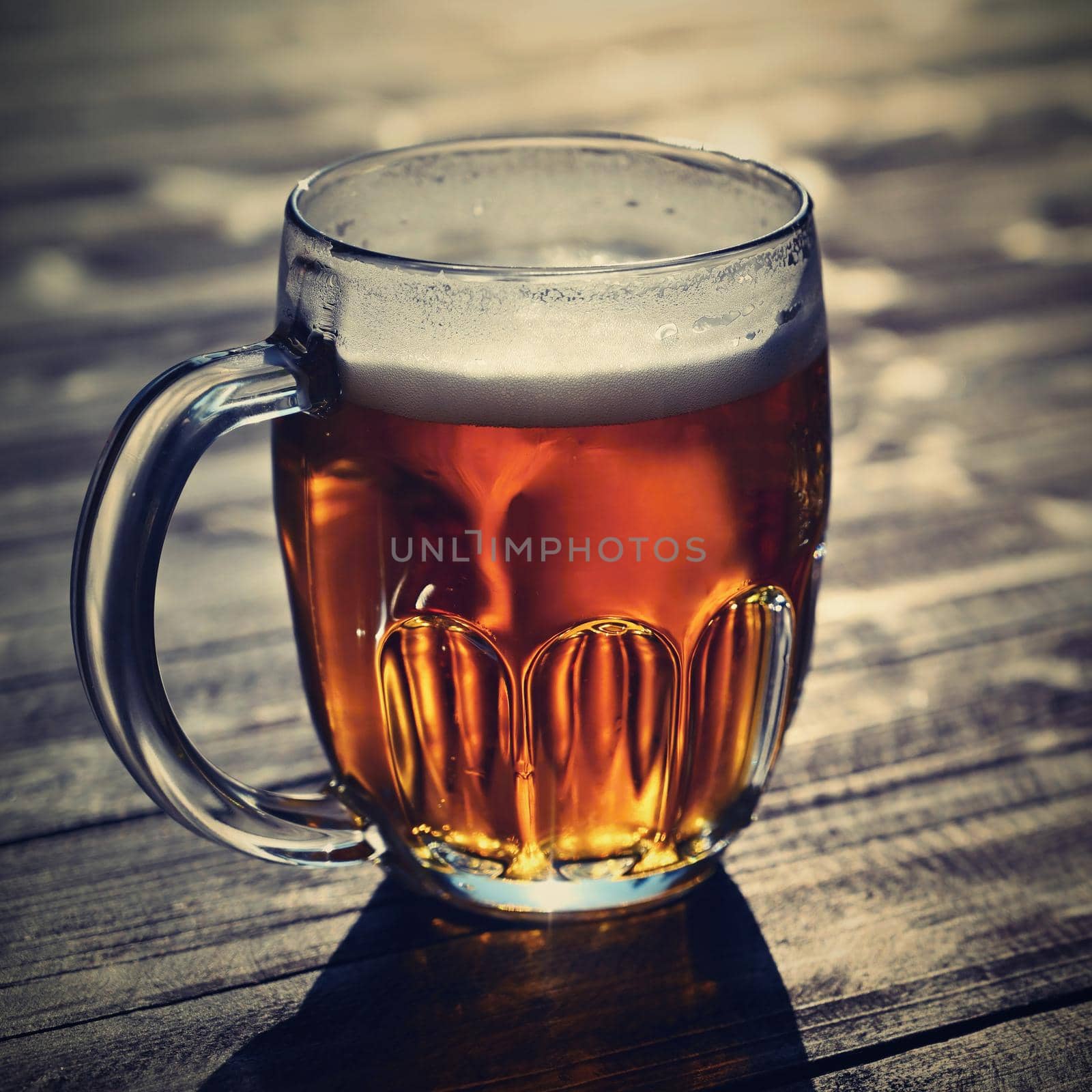 Refreshing fresh draft beer in a dewy glass. Good and honest Czech quality beer on a wooden table background